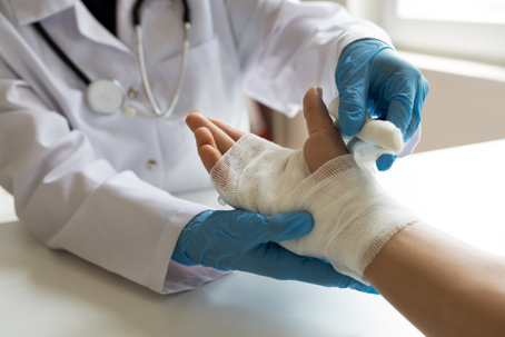 Doctor wrapping patient's hands with bandage stock photo
