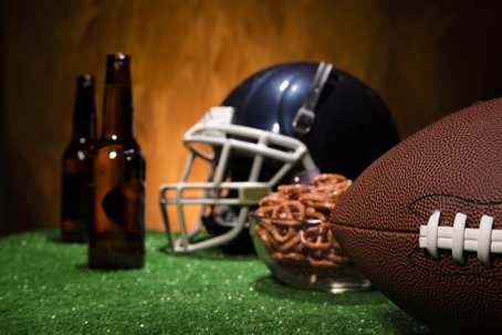 Football helmet, ball on artificial turf. Beer and pretzels.