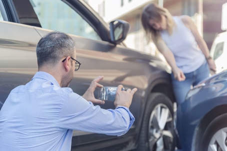 two people documenting car accident
